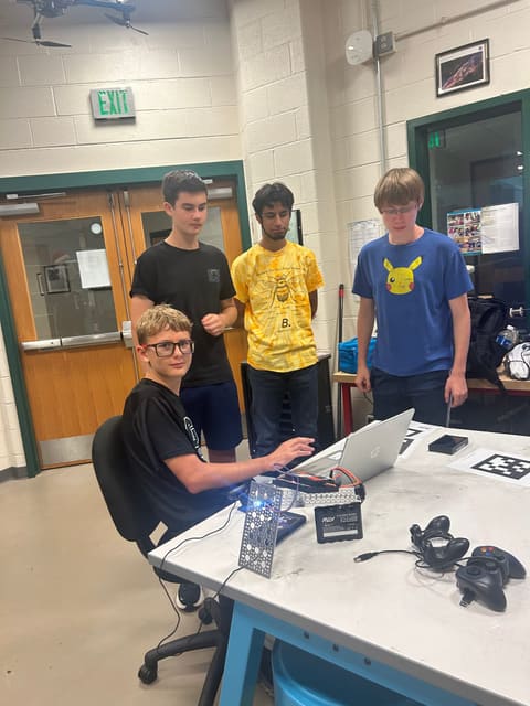 Four students around a laptop