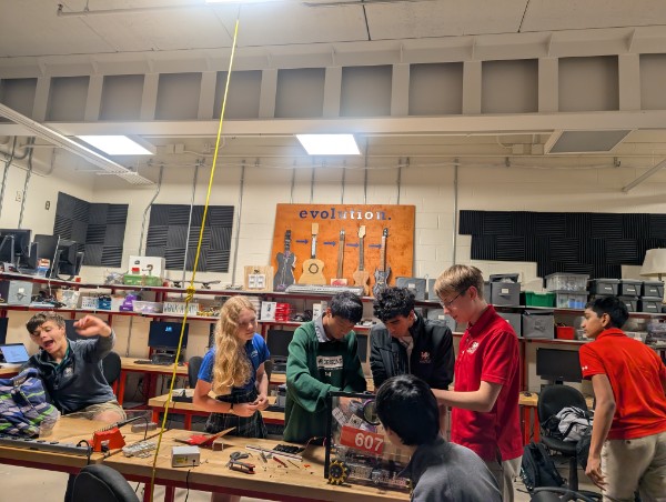 A busy Saturday in the robotics shop with students at several workbenches