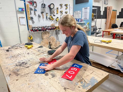 Red and blue 607 number plates on a workbench